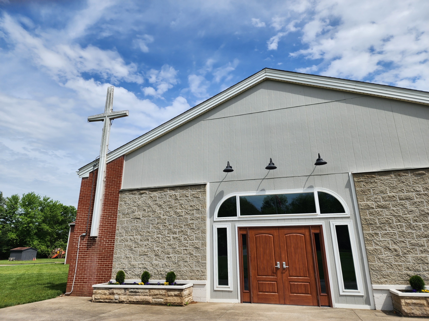 A church with a wooden door and a cross.